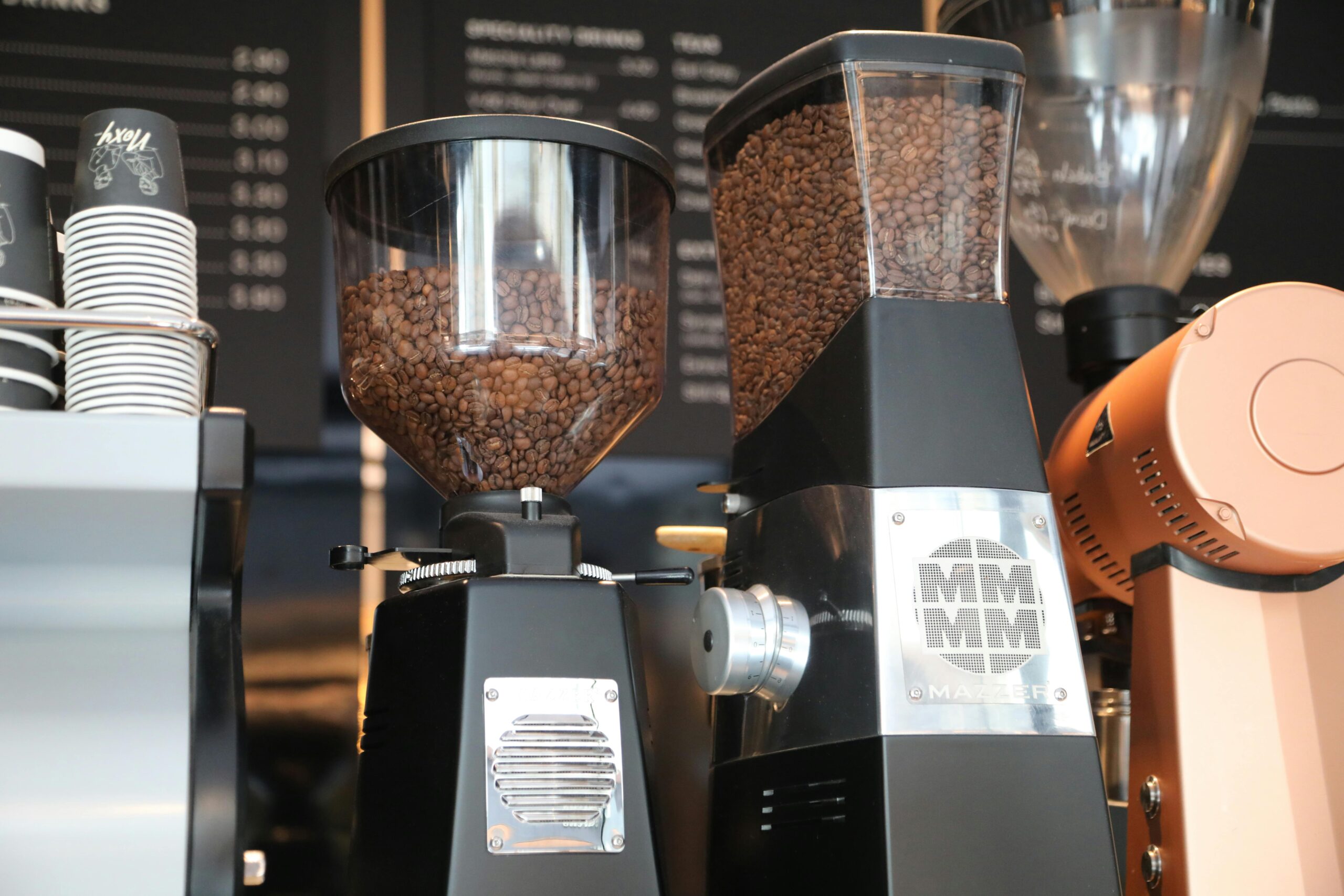 Close-up of coffee grinders filled with beans in a London cafe.